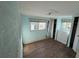 Light blue bedroom with a window, wood floor, white dresser and closet, and natural light at 2601 Gulf N Dr # 613, Bradenton Beach, FL 34217