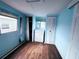 Light blue bedroom with wood floor, white dresser and closet, and natural light at 2601 Gulf N Dr # 613, Bradenton Beach, FL 34217