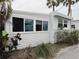 Cozy home exterior featuring white siding, mature landscaping, and updated windows at 2601 Gulf N Dr # 613, Bradenton Beach, FL 34217