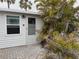 Charming cottage-style home featuring a white exterior, palm tree, and quaint brick walkway at 2601 Gulf N Dr # 613, Bradenton Beach, FL 34217