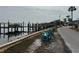 Scenic waterfront view with a private pier and colorful beach chairs, offering a tranquil outdoor experience at 2601 Gulf N Dr # 613, Bradenton Beach, FL 34217