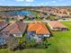 Aerial view of a house with a private screened pool, tile roof, and lush green backyard at 10120 Carnoustie Pl, Bradenton, FL 34211