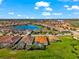 An aerial view of the home within a residential community, showcasing a lake and neighboring homes at 10120 Carnoustie Pl, Bradenton, FL 34211