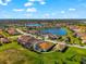 Aerial shot shows a house in a lakeside community surrounded by trees and other well-maintained properties at 10120 Carnoustie Pl, Bradenton, FL 34211