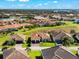 Scenic aerial view of a suburban neighborhood with well-maintained lawns, tile roofs and a serene lake at 10120 Carnoustie Pl, Bradenton, FL 34211