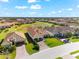 Wide aerial shot of a residential area with multiple houses, green lawns and mature trees at 10120 Carnoustie Pl, Bradenton, FL 34211