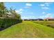 Green backyard with a view of the beautiful well-manicured landscaping and mature trees and green lawn at 10120 Carnoustie Pl, Bradenton, FL 34211