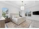 Bright bedroom features plantation shutters, a pendant light, a TV, and a decorative rug at 10120 Carnoustie Pl, Bradenton, FL 34211