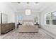 A well-lit bedroom features a pendant light, plantation shutters, and a decorative rug at 10120 Carnoustie Pl, Bradenton, FL 34211