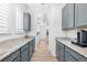 Butler's pantry with gray cabinets, granite countertops, and wood floors at 10120 Carnoustie Pl, Bradenton, FL 34211