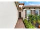 View of the home's entryway showing the front door, brick walkway, and decorative shutters at 10120 Carnoustie Pl, Bradenton, FL 34211