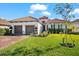 Home exterior showing the beautiful tile roof, brick driveway, well-kept lawn and nice landscape at 10120 Carnoustie Pl, Bradenton, FL 34211