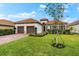 Inviting one-story home with lush landscaping, a two-car garage, and a red-tiled roof at 10120 Carnoustie Pl, Bradenton, FL 34211