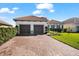 Well-maintained home exterior with paver driveway, lush lawn, and manicured shrubbery on a sunny day at 10120 Carnoustie Pl, Bradenton, FL 34211