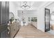 Bright foyer featuring wood-look flooring, a modern chandelier, and an open view into dining and living areas at 10120 Carnoustie Pl, Bradenton, FL 34211