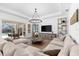 Spacious living room with wood-look tile flooring, large sectional sofa, and sliding glass doors to the lanai at 10120 Carnoustie Pl, Bradenton, FL 34211