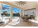 Inviting screened-in patio with tile flooring, ceiling fan, dining set, and BBQ grill near the outdoor pool area at 10120 Carnoustie Pl, Bradenton, FL 34211