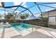 Gorgeous screened-in pool featuring clear blue water, elegant tiling, and a serene garden backdrop at 10120 Carnoustie Pl, Bradenton, FL 34211