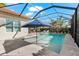 Inviting screened-in pool with a blue umbrella, outdoor seating, and views of the landscaped backyard at 10120 Carnoustie Pl, Bradenton, FL 34211