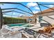 Backyard oasis features screened-in pool, spa, lounge chairs, fire feature and wicker chairs, perfect for relaxation at 10120 Carnoustie Pl, Bradenton, FL 34211