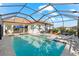 Wide angle view of a screened-in pool and spa featuring lounge seating and landscaped property at 10120 Carnoustie Pl, Bradenton, FL 34211