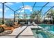 Inviting outdoor space with wicker chairs, lounge chairs and fire pit, situated beside the sparkling screened pool at 10120 Carnoustie Pl, Bradenton, FL 34211