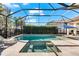 Stunning screened-in pool featuring a spa, lush landscaping, and ample space for lounging and entertainment at 10120 Carnoustie Pl, Bradenton, FL 34211