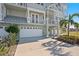 White garage doors and landscaping in front of a three-story building at 10390 Longshore Rd # 83, Placida, FL 33946