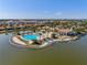 Aerial view of a stunning community clubhouse with a resort-style pool, lounging areas, and tropical landscaping at 109 Porta Vecchio Bnd # 202, Nokomis, FL 34275