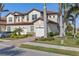 Beautiful home exterior featuring a tile roof, manicured landscaping, a paver driveway and a three-car garage at 109 Porta Vecchio Bnd # 202, Nokomis, FL 34275