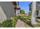 Landscaped walkway alongside house featuring decorative plants and a view of the pond and backyard at 109 Porta Vecchio Bnd # 202, Nokomis, FL 34275