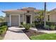 House exterior with landscaping and two-car garage at 110 Asti Ct, North Venice, FL 34275