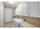 Bright laundry room with washer, dryer, cabinets, and sink at 110 Asti Ct, North Venice, FL 34275