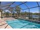 Lush pool area with screened enclosure and water feature at 110 Asti Ct, North Venice, FL 34275