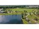 An aerial view shows lush green spaces, a pond, and winding walking paths in the neighborhood park at 12029 Perennial Pl, Lakewood Ranch, FL 34211