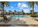 Community pool surrounded by lounge chairs and tropical landscaping under a partly cloudy blue sky at 12029 Perennial Pl, Lakewood Ranch, FL 34211