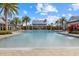 Community pool surrounded by lounge chairs, tropical landscaping, and shaded seating areas at 12029 Perennial Pl, Lakewood Ranch, FL 34211