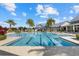 Community pool featuring marked lanes for swimming, inviting steps, tropical landscaping, and nearby seating at 12029 Perennial Pl, Lakewood Ranch, FL 34211