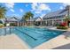 Community pool featuring marked lanes for swimming with inviting steps, tropical landscaping, and nearby seating at 12029 Perennial Pl, Lakewood Ranch, FL 34211