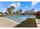 Community pool surrounded by lounge chairs and tropical landscaping under a partly cloudy blue sky at 12029 Perennial Pl, Lakewood Ranch, FL 34211