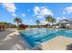 A large community pool is surrounded by palm trees and lounge chairs, with a covered patio area nearby at 12029 Perennial Pl, Lakewood Ranch, FL 34211