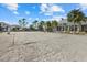 Sand volleyball court with a net, near clubhouse and palm trees, under a blue sky with fair weather clouds at 12029 Perennial Pl, Lakewood Ranch, FL 34211