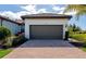 Two-car garage with paver driveway and manicured landscaping at 12251 Myrtle Bay Ct, Sarasota, FL 34238