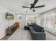 Bright living room features a modern ceiling fan, stylish gray sofa, and sleek light wood flooring at 1259 39Th St, Sarasota, FL 34234