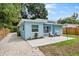 Charming light blue home exterior featuring a cozy outdoor patio and landscaped yard with fresh gravel at 1259 39Th St, Sarasota, FL 34234