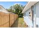 View of side yard of house with a new wooden fence and partial view of the home at 1259 39Th St, Sarasota, FL 34234