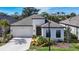 White one-story house with dark gray roof and landscaping at 15305 Isla Palma Ln, Nokomis, FL 34275