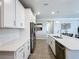 White kitchen with stainless steel appliances and ample counter space at 15305 Isla Palma Ln, Nokomis, FL 34275