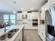 Modern kitchen with white cabinetry, quartz countertops and stainless steel appliances at 15305 Isla Palma Ln, Nokomis, FL 34275