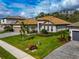 House exterior featuring a tile roof, palm trees and a paved driveway at 16219 Tradewind Ter, Bradenton, FL 34211